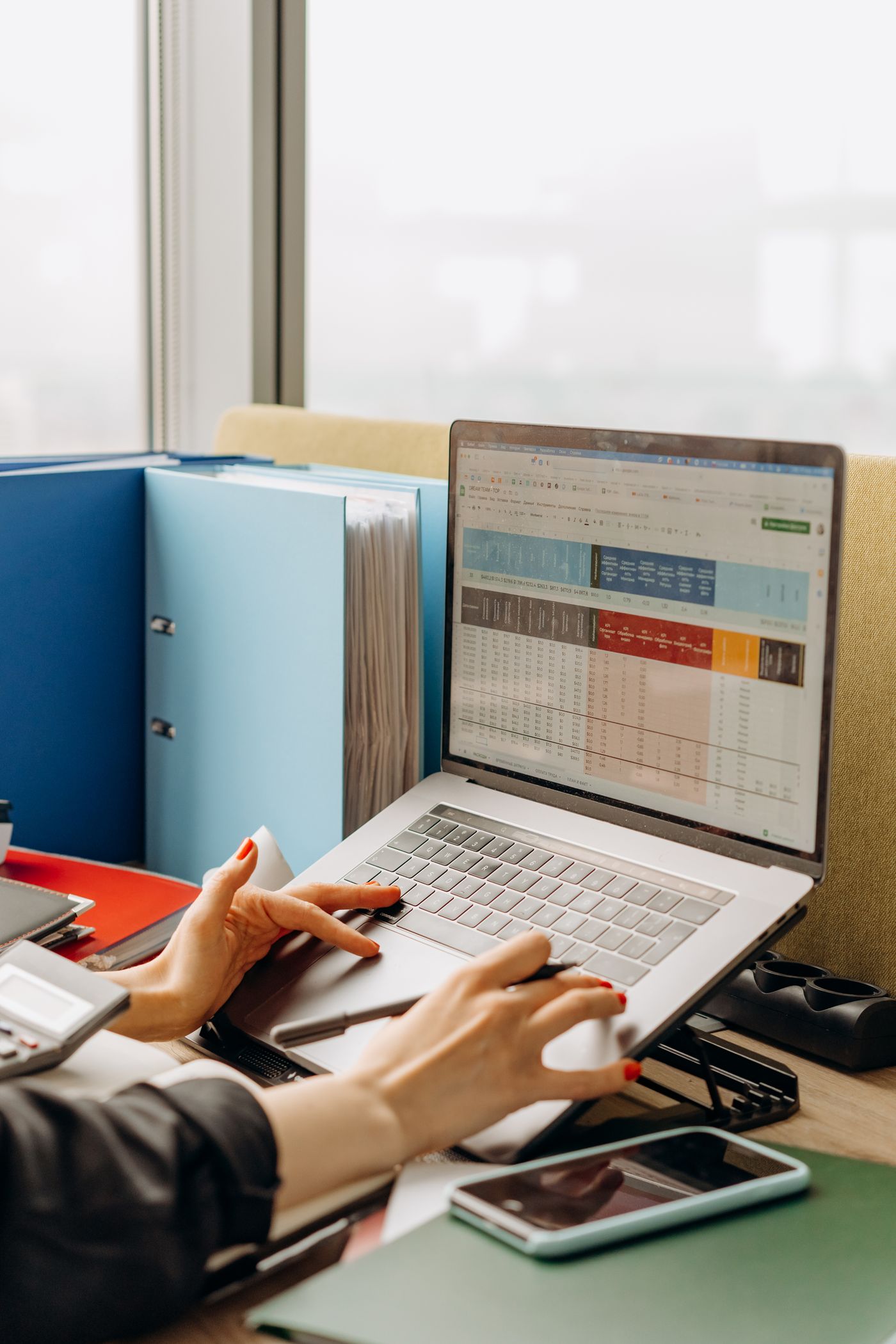 Laptop with market research spreadsheet and business files